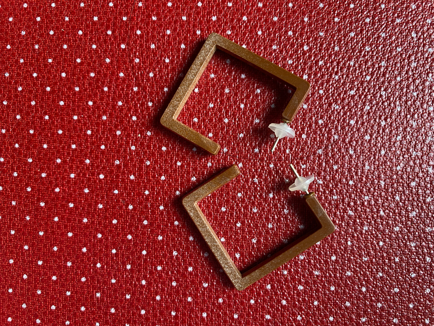 Authentic 80s Wooden like square-shaped earrings on a red retro polka dot fabric background