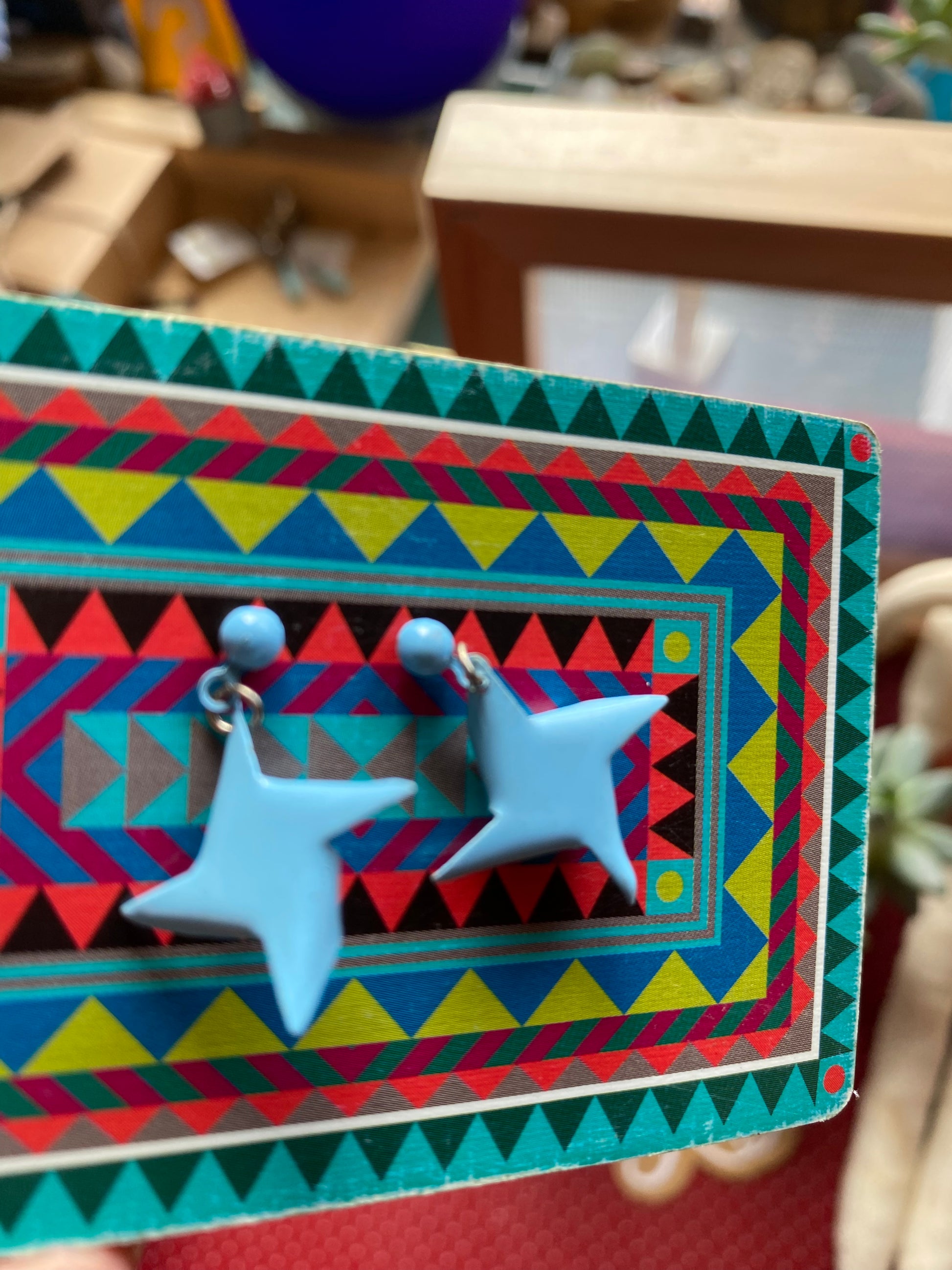 The back of a Star-shaped earrings on a colorful geometric card