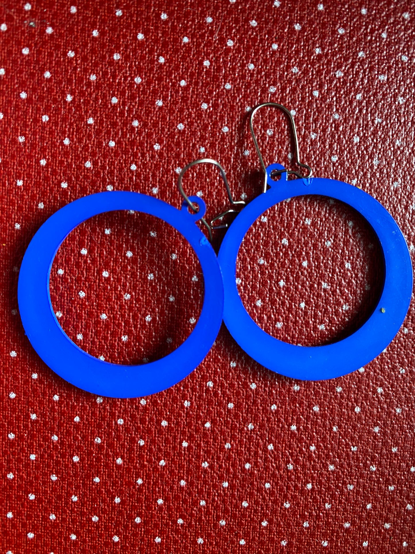 Blue hoop 80s earrings on a red polka dot background