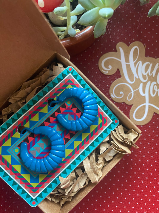 Blue 80s authentic earrings on a colorful card with a 'thank you' note in the background