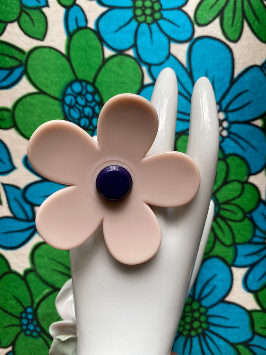 Handmade up-cycled daisy Flower-shaped ring with a navy center on a floral background