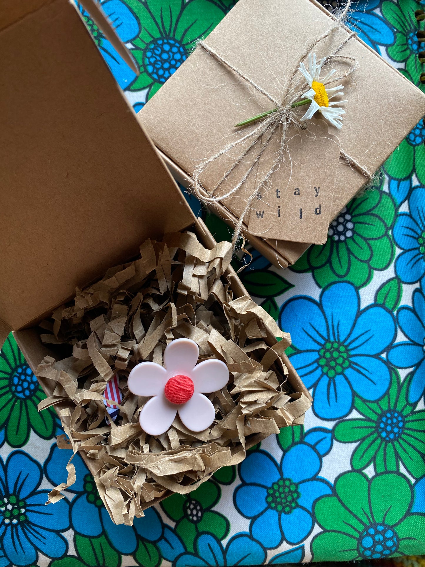 Handmade daisy ring in a Gift box with decorative elements on a floral-patterned surface