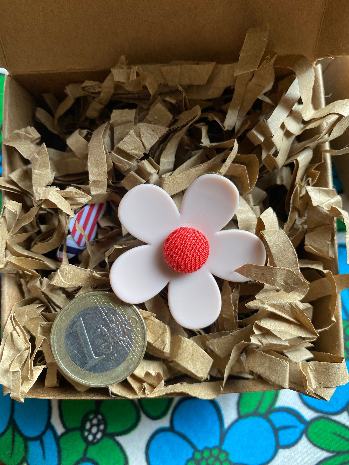 Handmade daisy pink flower with red center on brown paper inside a box