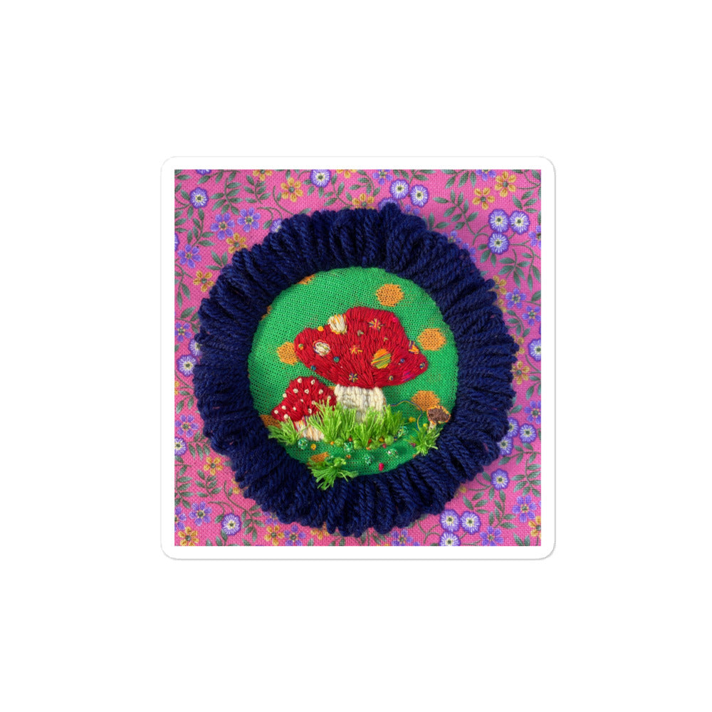 3D hand-embroidered red and white mushroom with colorful dots and grass on hoop