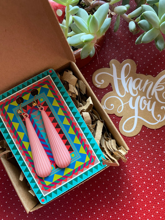 Pink authentic 80s earrings in a box with a 'thank you' card on a red retro polka dot background