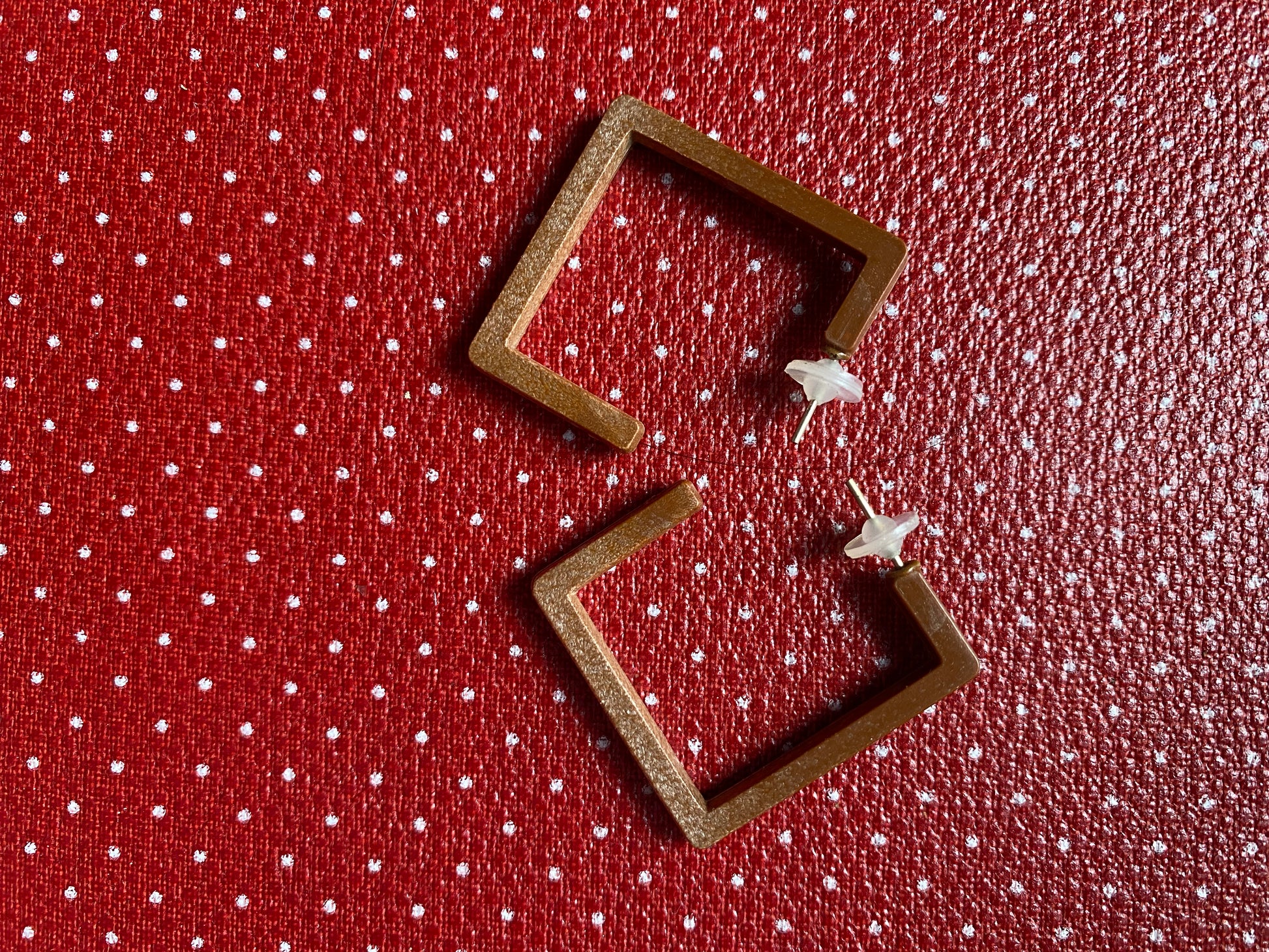 Authentic 80s Wooden like square-shaped earrings on a red retro polka dot fabric background