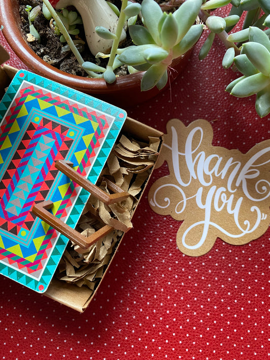 Colorful card with 80s retro geometric design, wooden alike and succulent plant on a red retro surface with 'Thank you' tag.