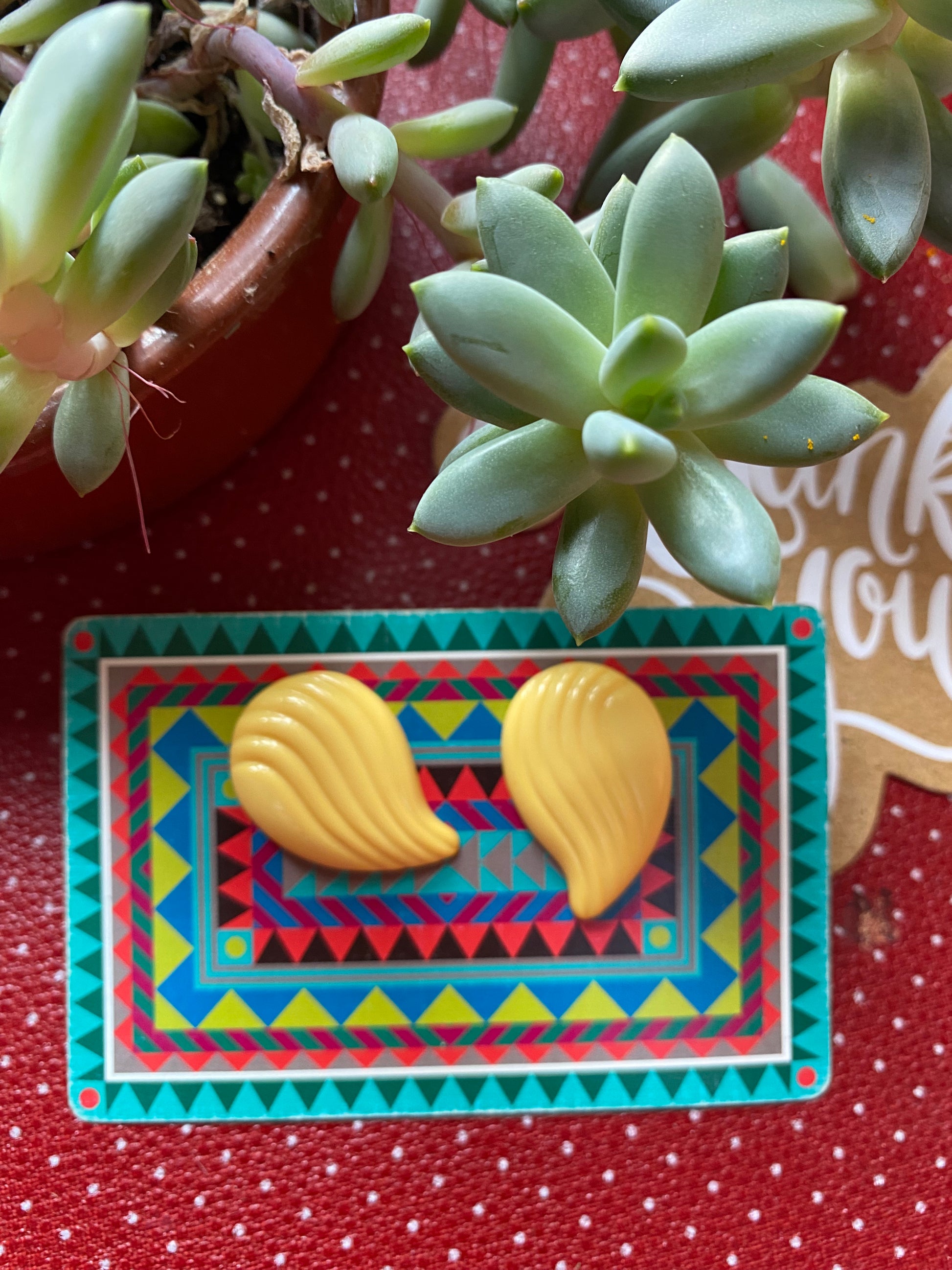 Colorful geometric card with two authentic 80s yellow shells earrings  on a red retro polka dot background 