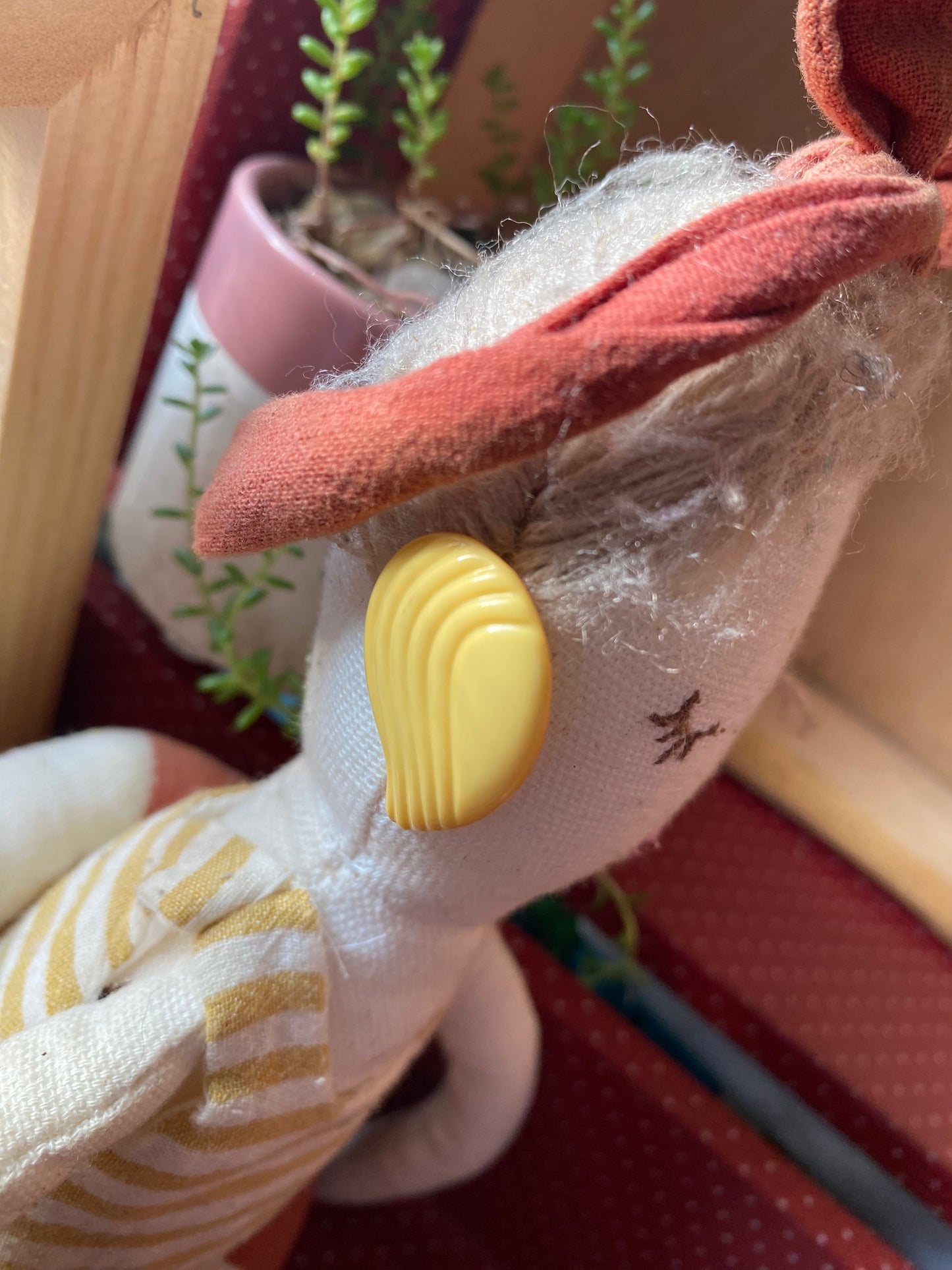 Close-up of a plush toy modelling a pair of yellow 80s earrings 