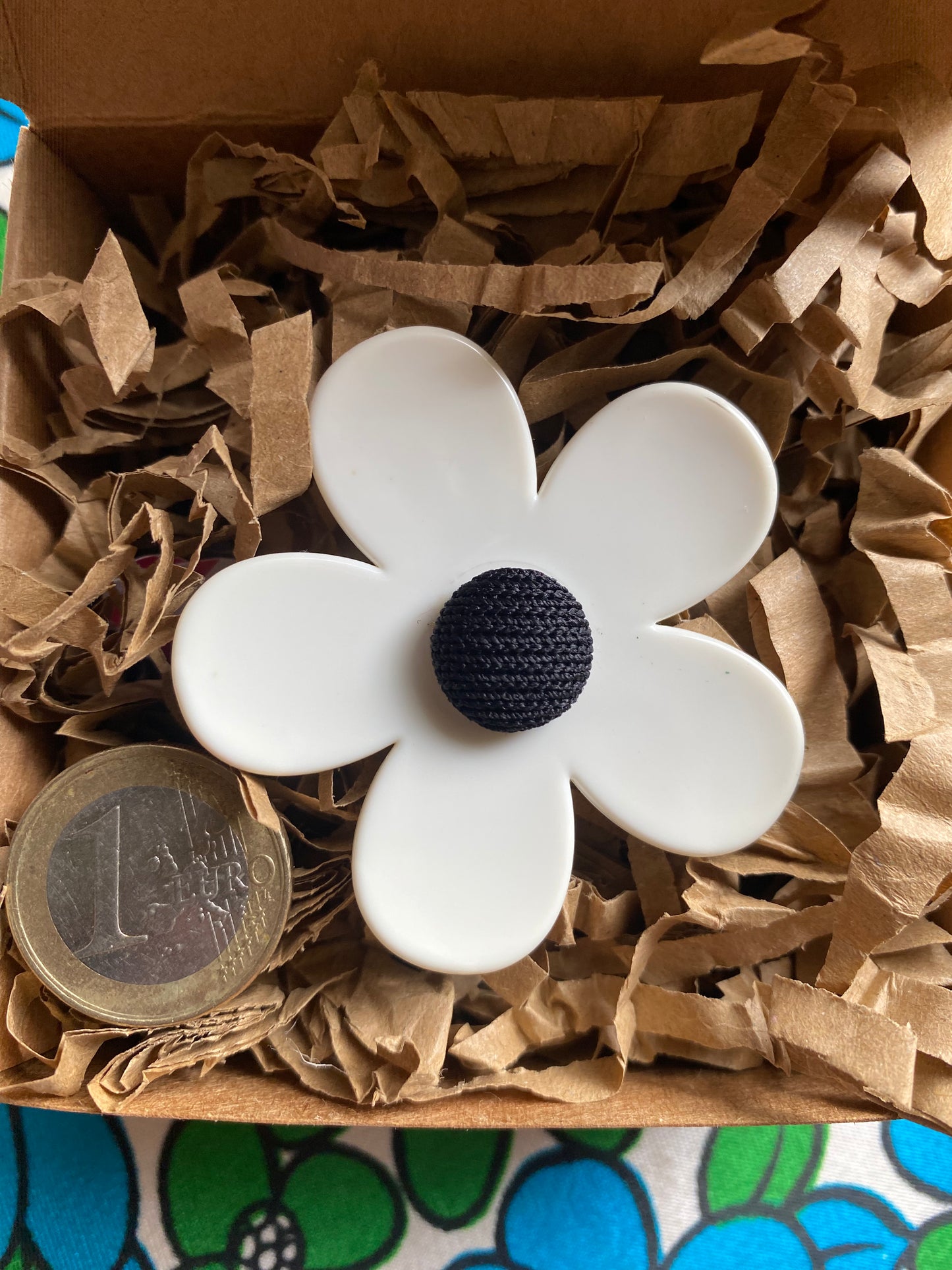 Handmade White daisy flower ring-with a black center on brown paper inside a gift box.