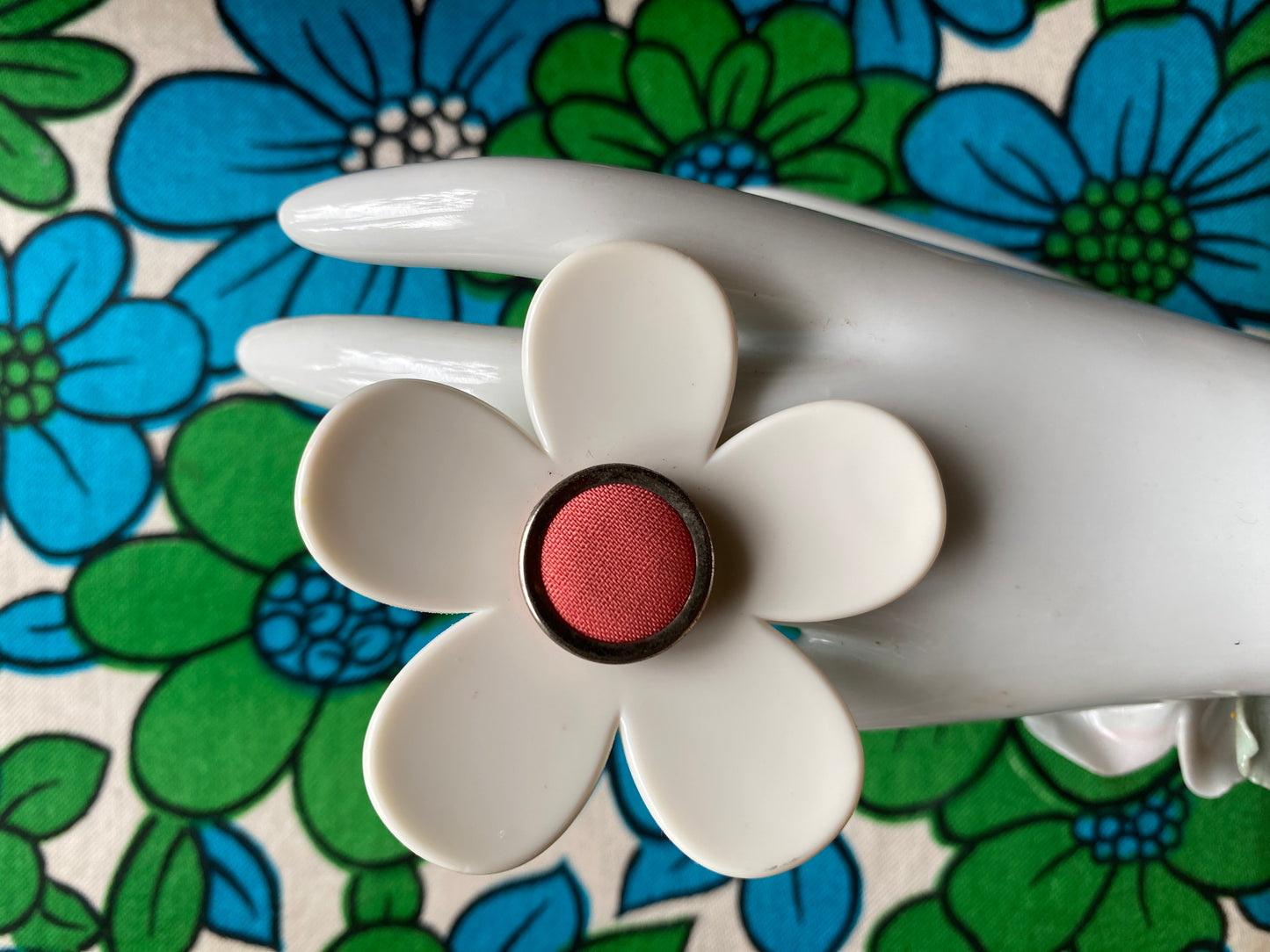 Handmade daisy Flower-shaped ring with a pink center on a floral background